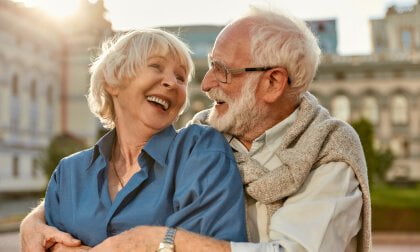 An older TheraLeaf Patient hugging in front of a city.