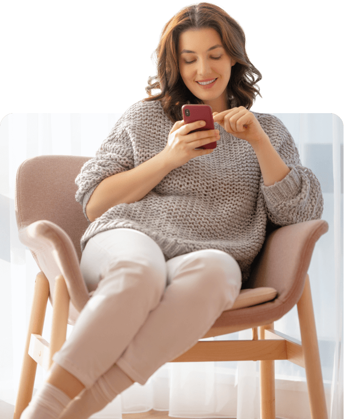 A woman sitting in a chair looking at TheraLeaf website