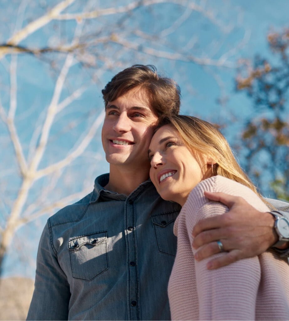 A man and woman embracing in the park.