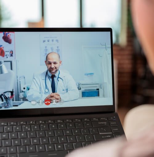 A woman is watching Theraleaf doctor on a laptop screen.