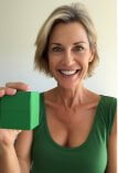 A woman holding up a green cube.