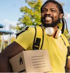 A man with headphones holding a box.